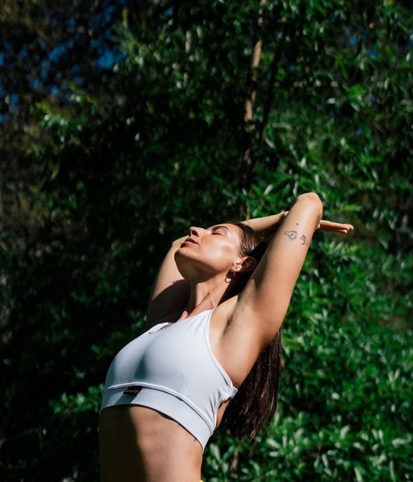 Woman performing a gentle core stability exercise in a serene setting.